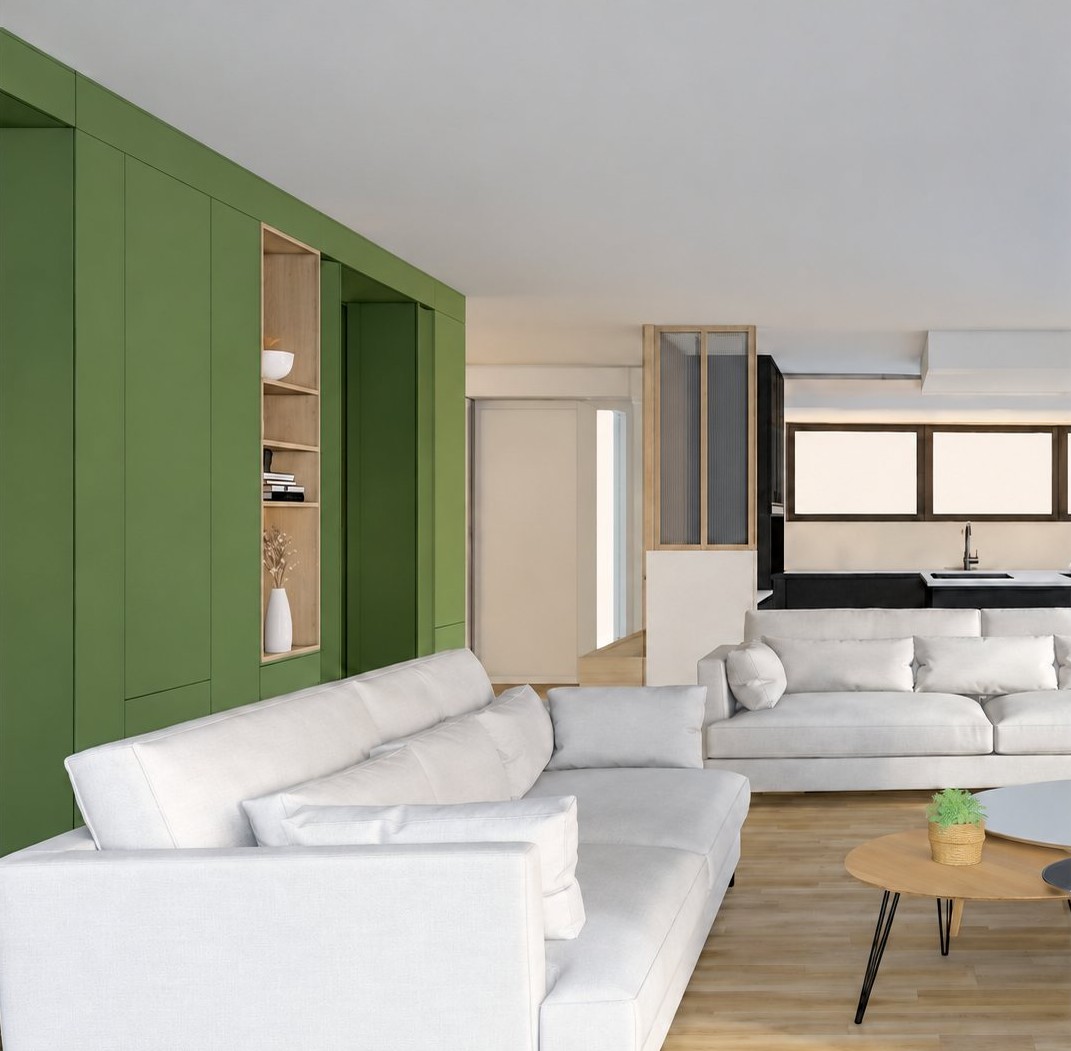 Salon moderne avec canapés blancs, table basse ronde et mur d’agencement vert.